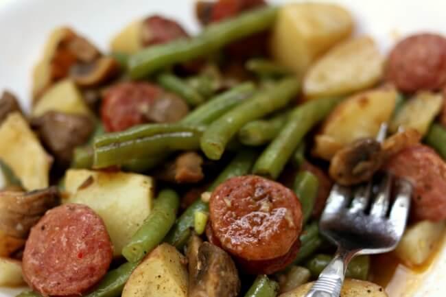 Slow Cooker Cajun Sausage, Potatoes and Green Beans--an easy one pot meal of cajun-style andouille sausage, quartered red potatoes, fresh green beans and sliced mushrooms. Drizzle the buttery broth over the potatoes for maximum flavor