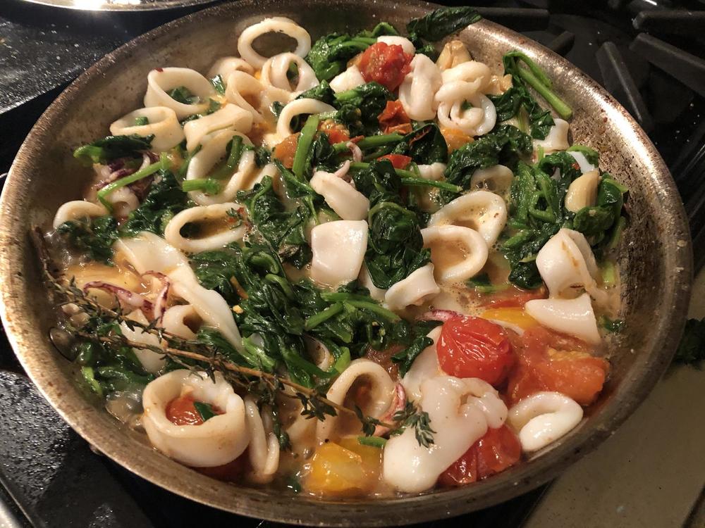 Calamari with tomatoes, garlic, wine, red pepper, thyme and spinach. 