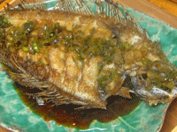 flounder.gif></a></p><p><strong>Dry fried flounder</strong> -- 乾煎龍利  <em>Ganjian longli</em></p><p>Serves 4 to 6 as part of a multicourse meal, or 2 to 3 as a main entree</p><p>1 whole flounder or other flatfish, about 1 pound (see Tips)</p><p>2 teaspoons sea salt</p><p>2 teaspoons Shaoxing rice wine</p><p>6 cups (or more) frying oil (see Tips)</p><p>2 tablespoons fresh peanut or vegetable oil</p><p>3 green onions, trimmed</p><p>3 tablespoons Shaoxing rice wine</p><p>3 tablespoons filtered water or stock</p><p>2 teaspoons regular soy sauce, or to taste</p><p>½ teaspoon sugar</p><p>1. Gut the fish by cutting under the chin and removing the small pouch of organs; scrape out any black skin in there, as this is often very bitter. Remove the gills, too, which look like pink eyelashes. Scale the fish by scraping a knife from tail to head on both sides of the fish; when you are done and all the scales have been washed off, the fish should look pink rather than gray. </p><p>2. Pat the fish dry with a paper towel or two and lay it on a cutting board. Use your knife to cut diagonal slashes a little more than an inch apart, from about a 10:00 position down to a 4:00 position; these should go all the way down to (but not through) the bones, and cover the entire width of the fish body, but do not cut into the frills around the edge. Flip the fish over and do the same thing. (Make sure that the cuts use the same angle on both sides so that when you hold the fish up to the light, you can see XXX marks down its body. This keeps the fish from falling apart as you fry it, while allowing the meat to cook very quickly.)</p><p>3. Lay the fish on a platter and rub the salt into both sides. Sprinkle it with the 2 teaspoons rice wine, and let it marinate for 10 to 20 minutes. At the end of this time, drain off all of the marinade and pat the fish very, very dry. Wipe out even the inside of the head and cavity so that there are no drops of water to explode in the hot oil. Then. lay the fish on a dry paper towel while you prepare everything else.</p><p>4. Pour enough frying oil into your wok so that it is at least 1½ inches deep; this will ensure that there is enough hot oil to rapidly fry the fish and make it both crispy and succulent. Heat the oil over high until it starts to smoke. While you are waiting, prepare a serving platter, and have a pair of cooking chopsticks, a wok spatula, and either a spatter screen or a large lid ready. Also, make the sauce in the next step so that it is ready when the fish is.</p><p>5. Prepare the sauce in a small pan by heating the remaining 2 tablespoons oil over high heat until it is sizzling, and then adding the green onions. Stir them quickly over the high heat to release their fragrance, and then add the rest of the rice wine, water or stock, soy sauce, and sugar. Bring the sauce to a boil, taste, and adjust the seasoning. Turn off the heat under the sauce.</p><p>6. While the oil is heating up, clear the kitchen of children and pets and anyone who will get in your way. </p><p>7. Holding the fish by the tail in one hand and either the spatter screen or the lid in your other, slide the fish into the hot oil and immediately cover the wok with the screen or lid, as the water in the flesh will start to explode. This will die down fast, and if you can, keep your grip on the tail so that you slide the fish around so that all of it gets a chance to brown. There is no need to flip the fish over if you have enough hot oil; just use your spatula to lightly press down on the fish and scoot it around. When the fish has fried for about 5 minutes, slide the tail end in so that all of the tail fin gets fried, too; this is a very thin part of the fish, so it will fry up fast. </p><p>8. Depending upon your fish, the heat of your stove, and the depth of the oil, the fish will be ready in about 7 to 10 minutes. It should be a golden brown all over, the fins and frills will be browned and crispy, and the meat will have pulled away from the bones where you slashed the flesh (see the top photo). Place your platter next to the wok. Use your spatula to scoop down under the fish body and your chopsticks to steady the tail end to lift up the fish, drain off the oil, and place it carefully on your platter. If you feel uneasy about this, use two spatulas, or even ask someone to help. (Turn off the heat and push the wok to the back of the stove out of harm