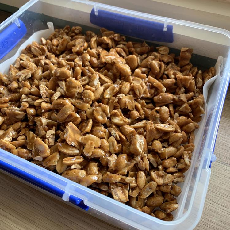 Plastic food storage container full of caramelized peanuts